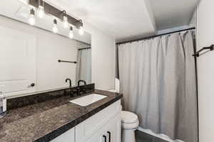 Bathroom with toilet, vanity, a textured ceiling, and tile patterned flooring