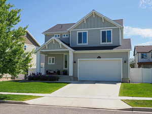 Craftsman-style home featuring board and batten siding, a porch, concrete driveway, and an attached garage