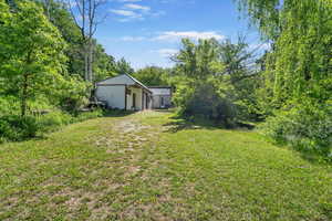 View of green lawn with  shed and garage