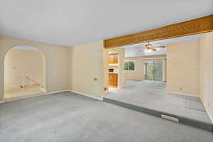 Living room off of entry with wood beam and arched entrance