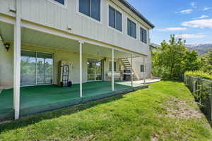 Rear view of house and walk-out basement with patio.