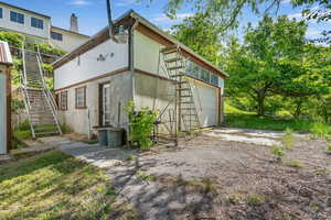 Rear view of property with 2 car detached garage/workshop and stairs. Garage has heat, electricity, plumbing and half bathroom.