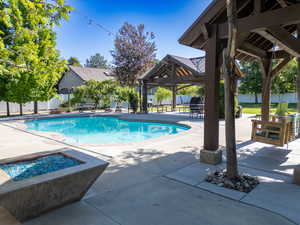 View of pool with a gazebo, a patio area, a fire pit, and a fenced backyard