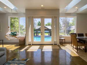 Entryway featuring a skylight, finished concrete floors, french doors, and recessed lighting