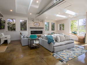 Living room featuring concrete flooring, plenty of natural light, baseboards, and recessed lighting
