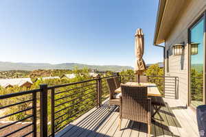 Wooden deck with a mountain view and outdoor dining space