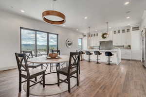 Dining area featuring recessed lighting, a mountain view, light wood finished floors, and baseboards