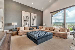 Living area with recessed lighting, wood finished floors, and high vaulted ceiling