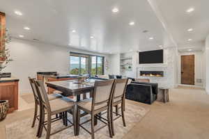 Dining room with recessed lighting, a stone fireplace, and baseboards
