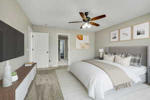 Bedroom featuring light carpet, baseboards, and ceiling fan