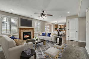 Living room with ceiling fan, baseboards, a premium fireplace, recessed lighting, and wood finished floors