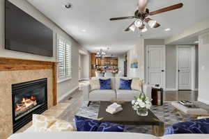 Living area with a chandelier, baseboards, a fireplace, a ceiling fan, and recessed lighting