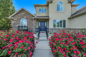 Doorway to property with stucco siding and stone siding