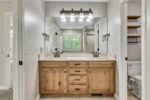 Full bathroom with toilet and double vanity