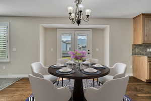 Dining room featuring a chandelier, baseboards, and dark wood-style floors