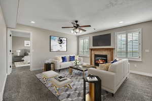 Living room featuring a fireplace, carpet floors, a ceiling fan, baseboards, and recessed lighting