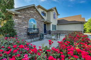 Traditional home with stucco siding, stone siding, and a patio area