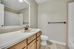 Bathroom with vanity, toilet, tile patterned floors, and baseboards