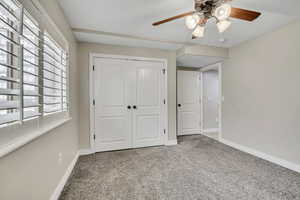 Unfurnished bedroom featuring carpet, baseboards, a closet, and a ceiling fan