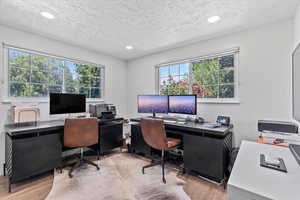 Office area with wood finished floors, plenty of natural light, a textured ceiling, and recessed lighting
