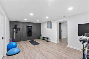 Workout area featuring wood finished floors, recessed lighting, baseboards, and electric panel