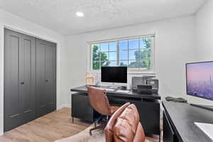 Home office with wood finished floors, a textured ceiling, and recessed lighting