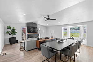 Dining room with light wood-style flooring, a ceiling fan, lofted ceiling, baseboards, and recessed lighting