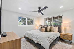 Bedroom featuring multiple windows, baseboards, light wood-style flooring, recessed lighting, and a ceiling fan