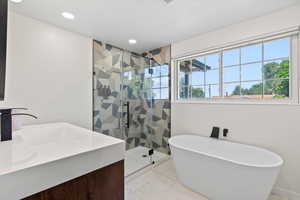 Bathroom with a shower stall, a freestanding tub, vanity, recessed lighting, and marble finish floors