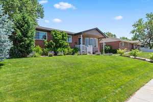 Ranch-style house featuring brick siding and a front lawn