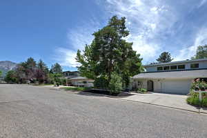 View of front facade with driveway, a mountain view, and brick siding