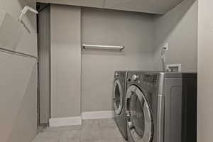 Laundry room with washing machine and dryer and baseboards