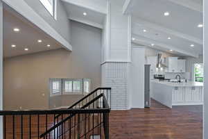 Hallway featuring high vaulted ceiling, a sink, beam ceiling, recessed lighting, and dark wood finished floors