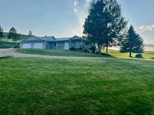 View of front of house with a garage and a front lawn