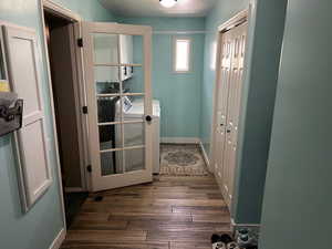 Entryway with wood finished floors, independent washer and dryer, and a textured ceiling