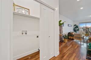 Laundry area with electric dryer hookup, hookup for a washing machine, wood finished floors, recessed lighting, and baseboards