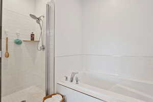 Bathroom featuring a bath and a stall shower
