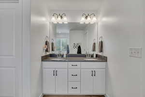 Bathroom with double vanity and baseboards