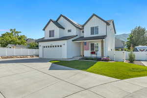 Modern farmhouse featuring a gate, board and batten siding, a garage, concrete driveway, and a mountain view