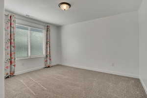 Unfurnished room with carpet flooring and baseboards
