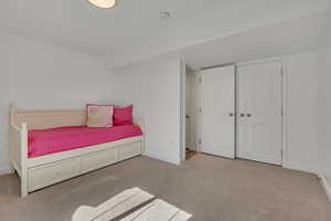 Carpeted bedroom featuring baseboards and a closet