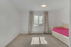 Carpeted bedroom featuring baseboards