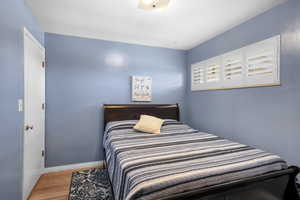 Hardwood Floors in this Secondary Bedroom, featuring a Queen Sized Bed!