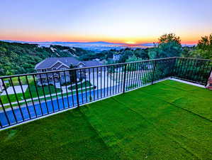 Yard at dusk featuring a balcony and a yard