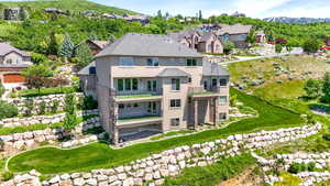 Back of property featuring a balcony, stucco siding, a residential view, and a mountain view