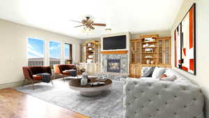 Living area with wood finished floors, a ceiling fan, a stone fireplace, and baseboards