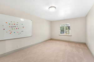 Carpeted spare room with baseboards