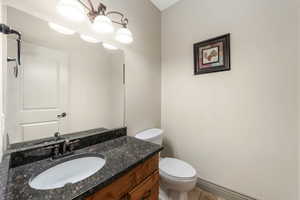 Bathroom with toilet, vanity, and tile patterned flooring