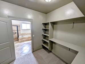 Spacious closet with light tile patterned floors
