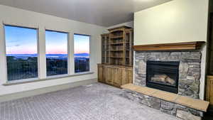Unfurnished living room featuring a fireplace and carpet